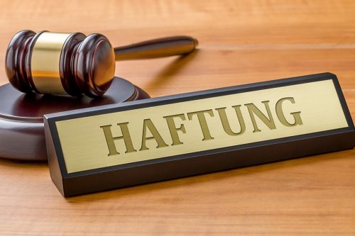 Schild mit Aufschrift Haftung und Richterhammer